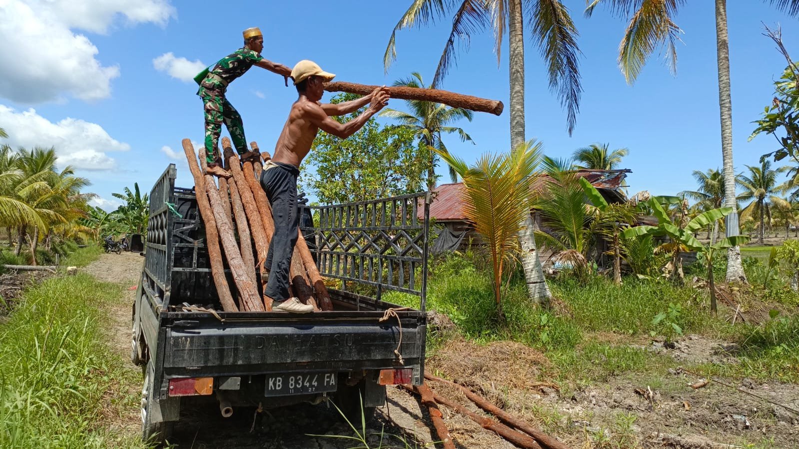 Anggota Satgas TMMD Reguler ke-124 Bantu Warga Turunkan Kayu untuk Kandang Ayam