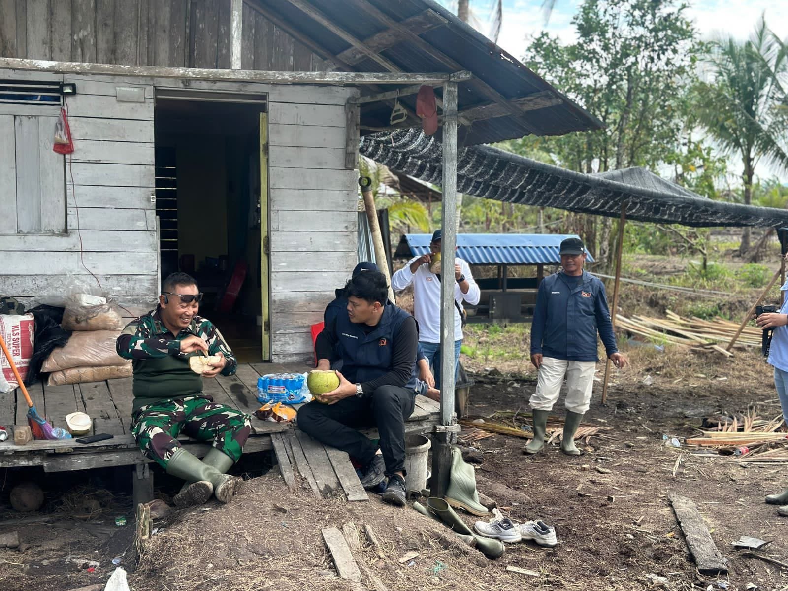 Hangatkan Sinergi, Dansatgas TMMD Jamu Tim CSR PT. BAI dengan Kelapa Muda di Tengah Hijau Demplot