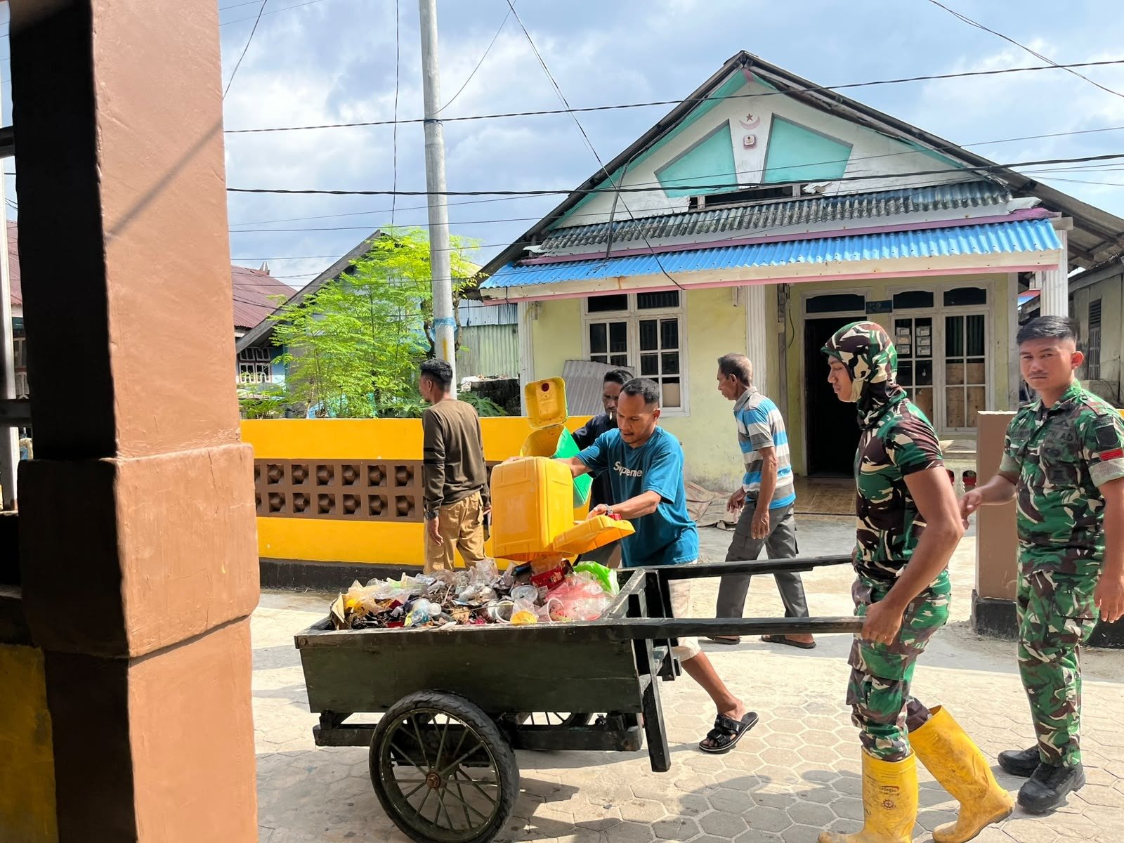 Kerja Sama Satgas TMMD dan Masyarakat dalam Membersihkan Sampah di Desa Umbele